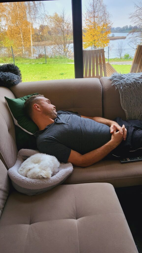 Nie ma nic lepszego niż leniwe popołudnie w Hytte Na Wyspie. Drzemka na wygodnej sofie, wtulony piesek i widok na zalew – tutaj czas płynie inaczej. Cisza, natura i błogi relaks.