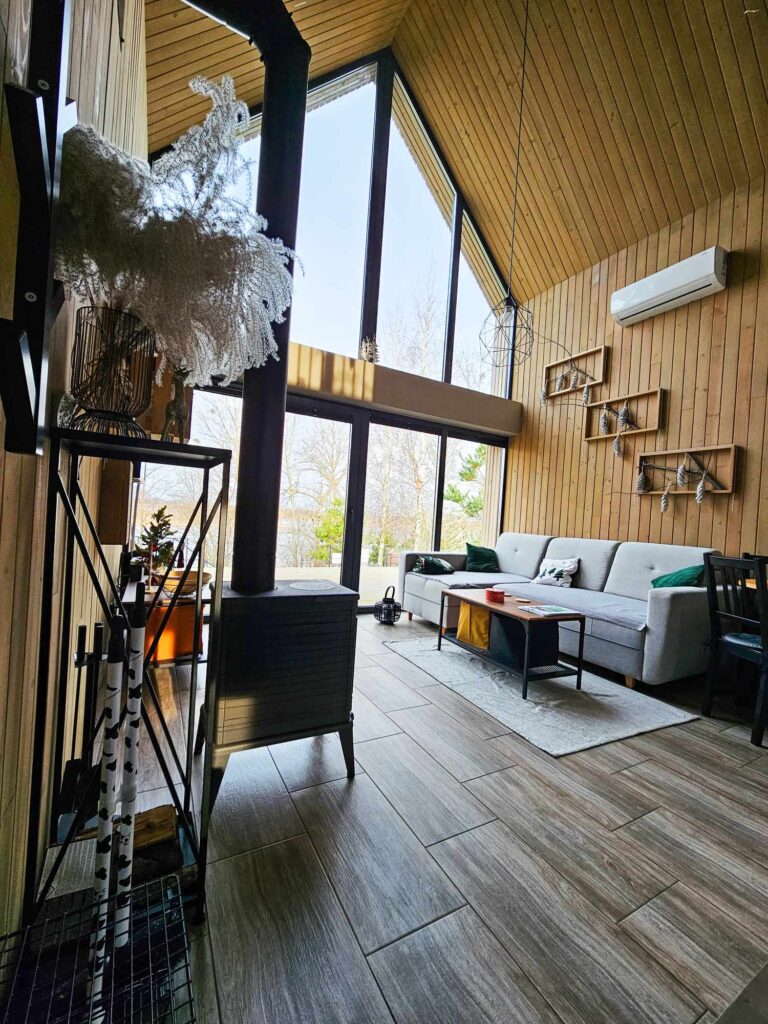 Przytulny salon z kominkiem – idealne miejsce na odpoczynek przy ogniu i relaks w otoczeniu natury. 