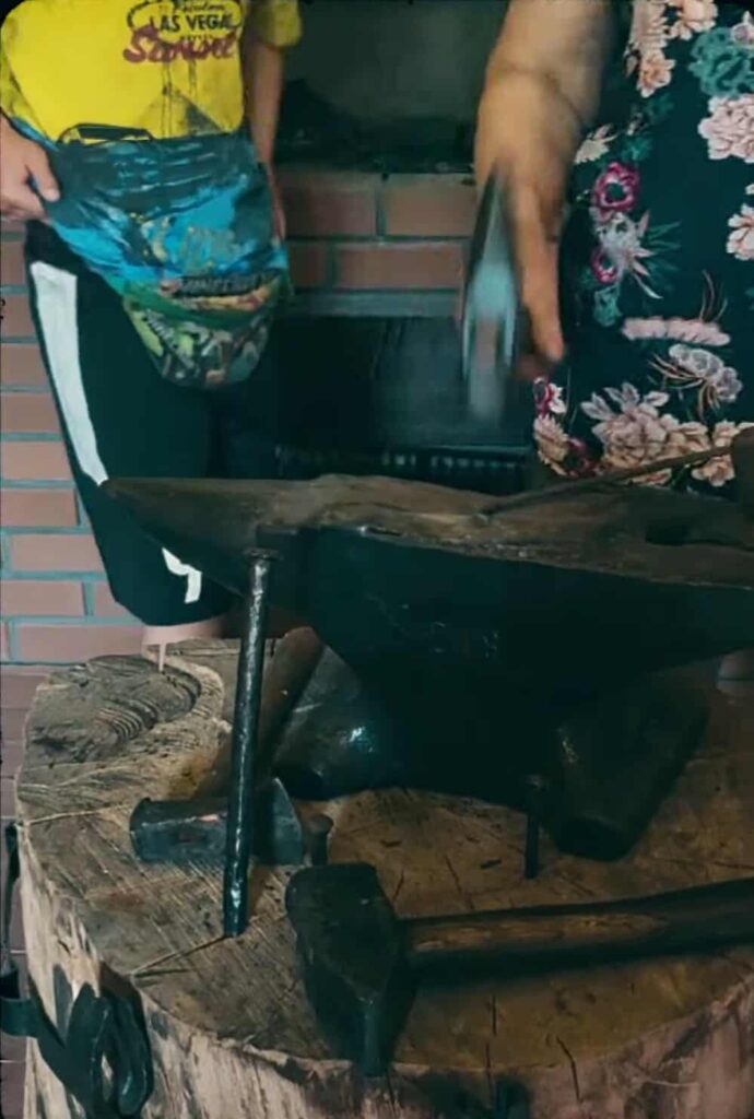 Zrekonstruowane wnętrze wiejskiej kuźni z narzędziami kowalskimi